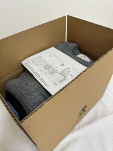 段ボールに入ったレンタル服が伝票と入っているシーン